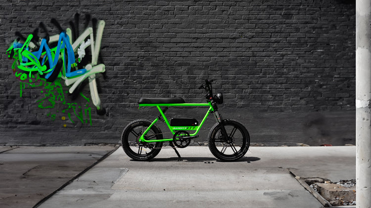 light green fat tire electric bike in front of a gray wall