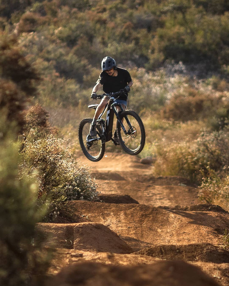 Man doing a jump with an electric Mountainbike on a trail