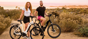 A women and a men standing with two step trough ebikes close to the ocean 
